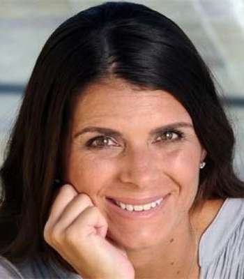 Mia Hamm smiling at camera with hand on chin